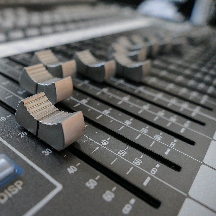 Faders on an audio mixing desk.
